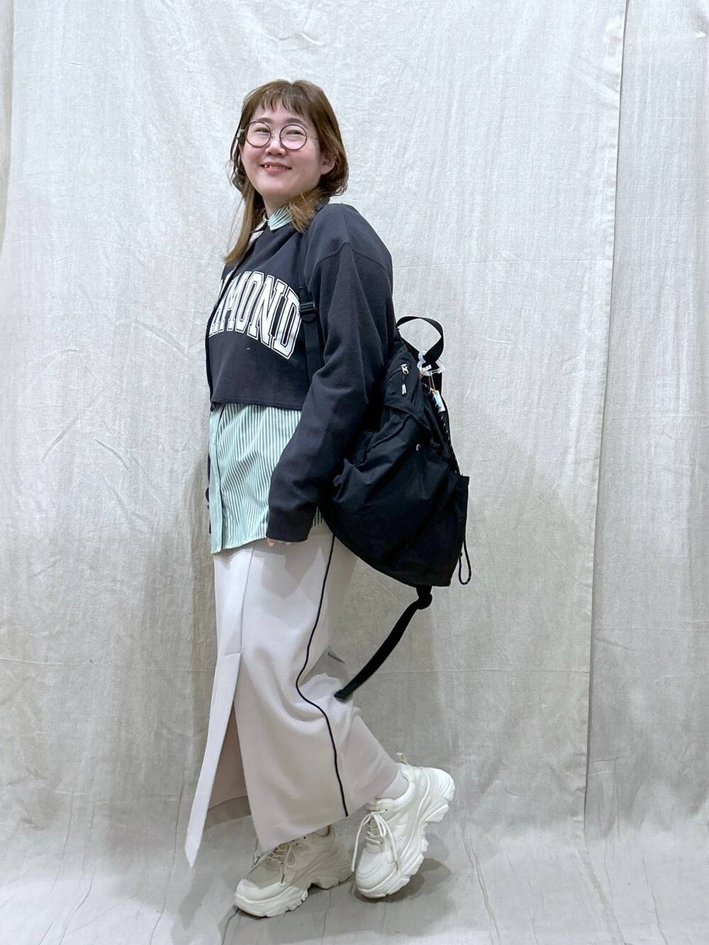 ブラック系のバックパック/リュック、グレー系のスウェット、グリーン系のシャツ/ブラウスを着用したレディースの冬コーディネートの2枚目の写真