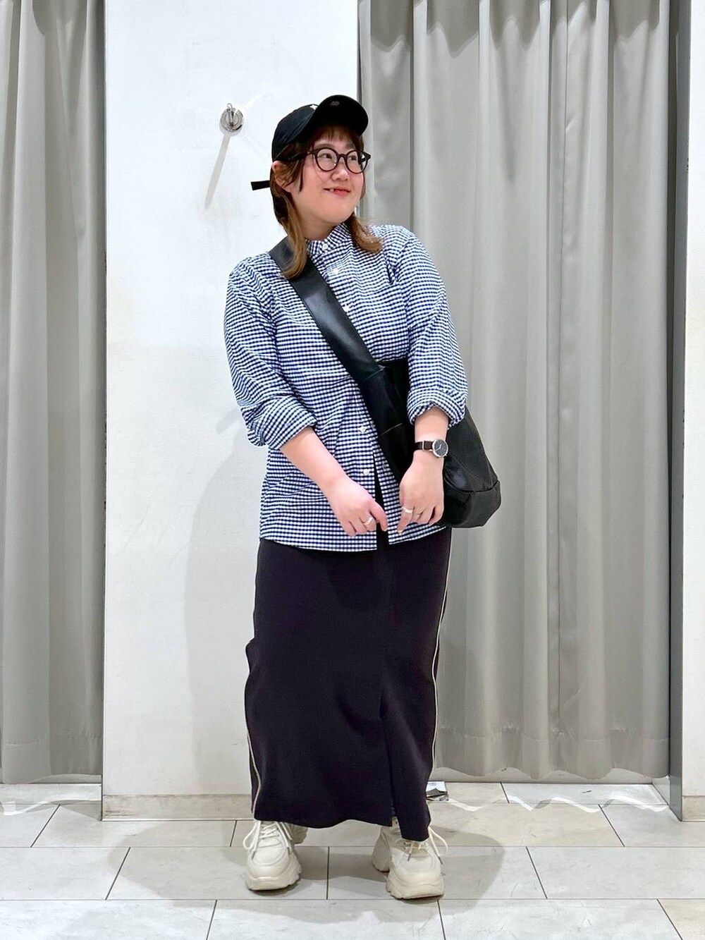 ブラック系のボディバッグ/ウエストポーチ、ホワイト系のスニーカー、グレー系のスカートを着用したレディースの冬コーディネートの3枚目の写真