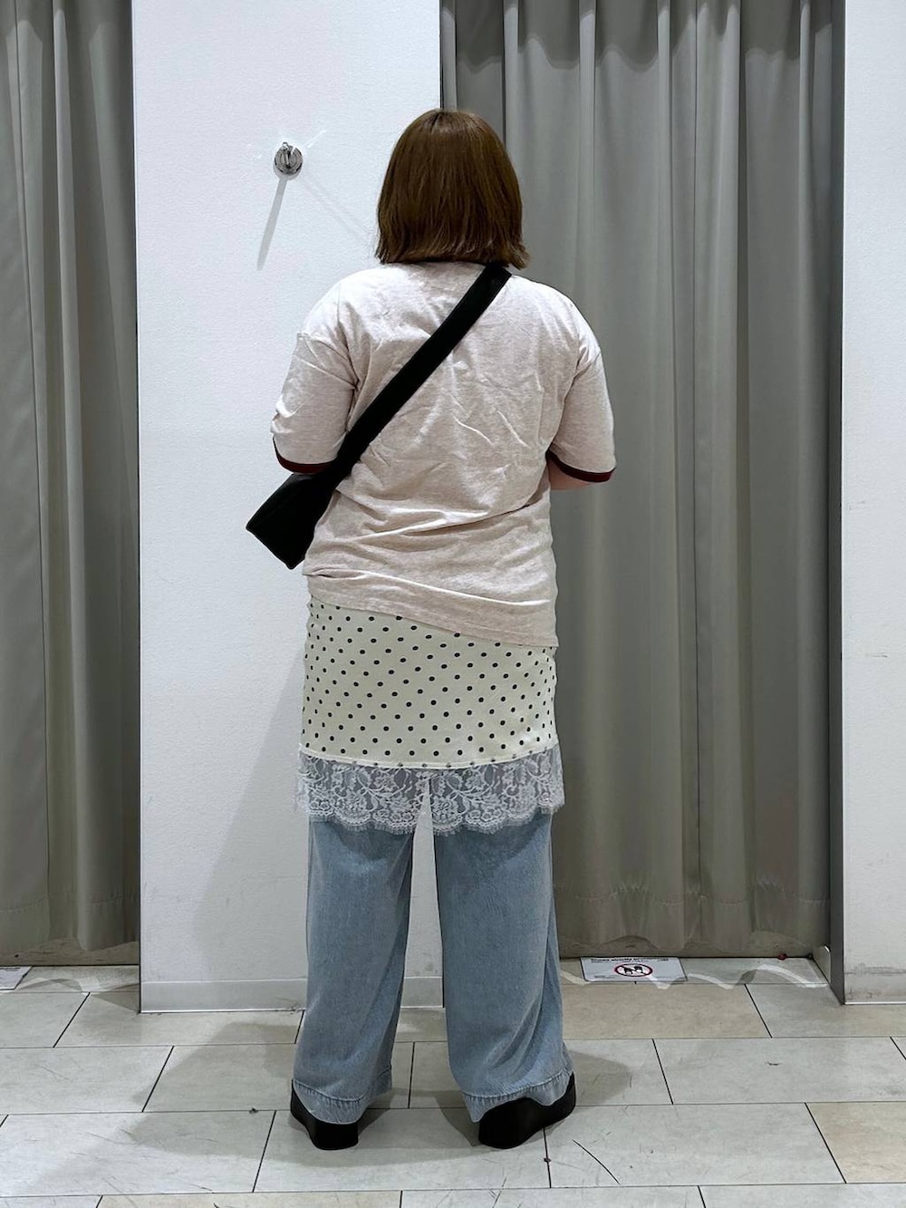 ブルー系のデニムパンツ、ブラック系のサンダル、ブラック系のショルダーバッグを着用したレディースの春コーディネートの5枚目の写真
