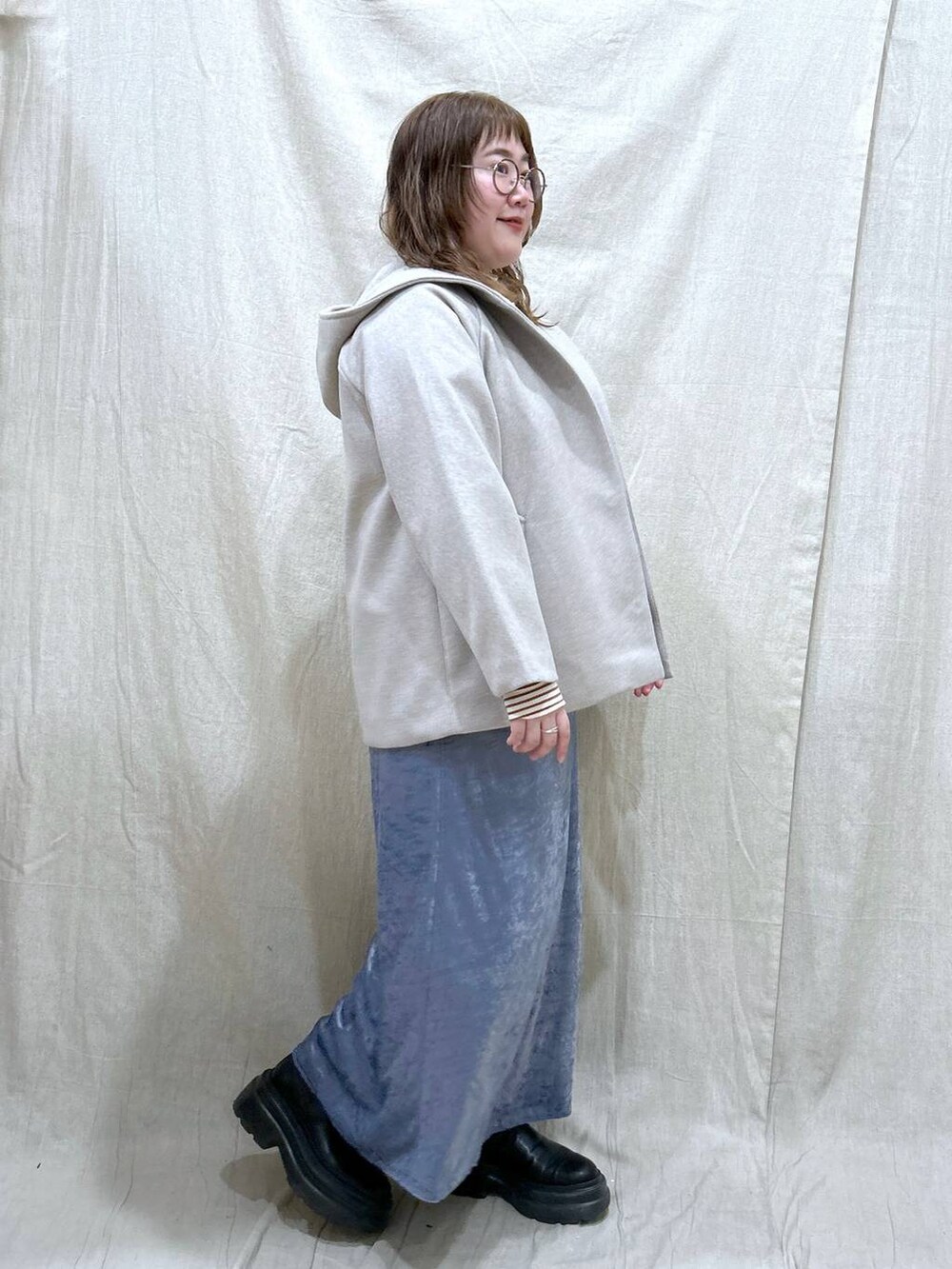 ブラウン系のTシャツ/カットソー、ベージュ系のその他アウター、ブラック系のブーツを着用したレディースの冬コーディネートの4枚目の写真