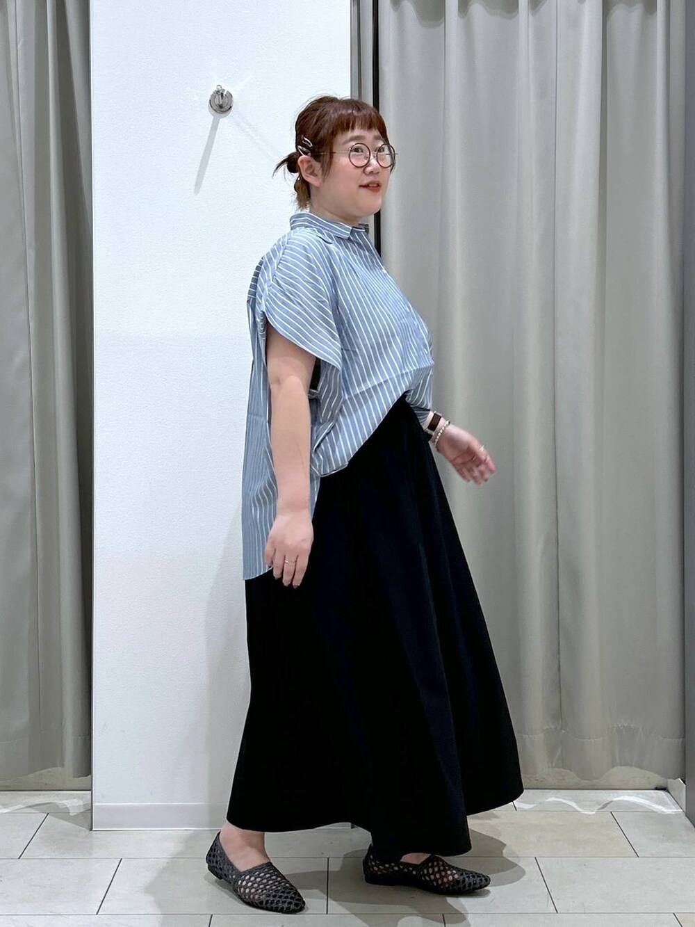 ブラック系のスカート、ブラック系のパンプス、ブルー系のシャツ/ブラウスを着用したレディースの夏コーディネートの6枚目の写真