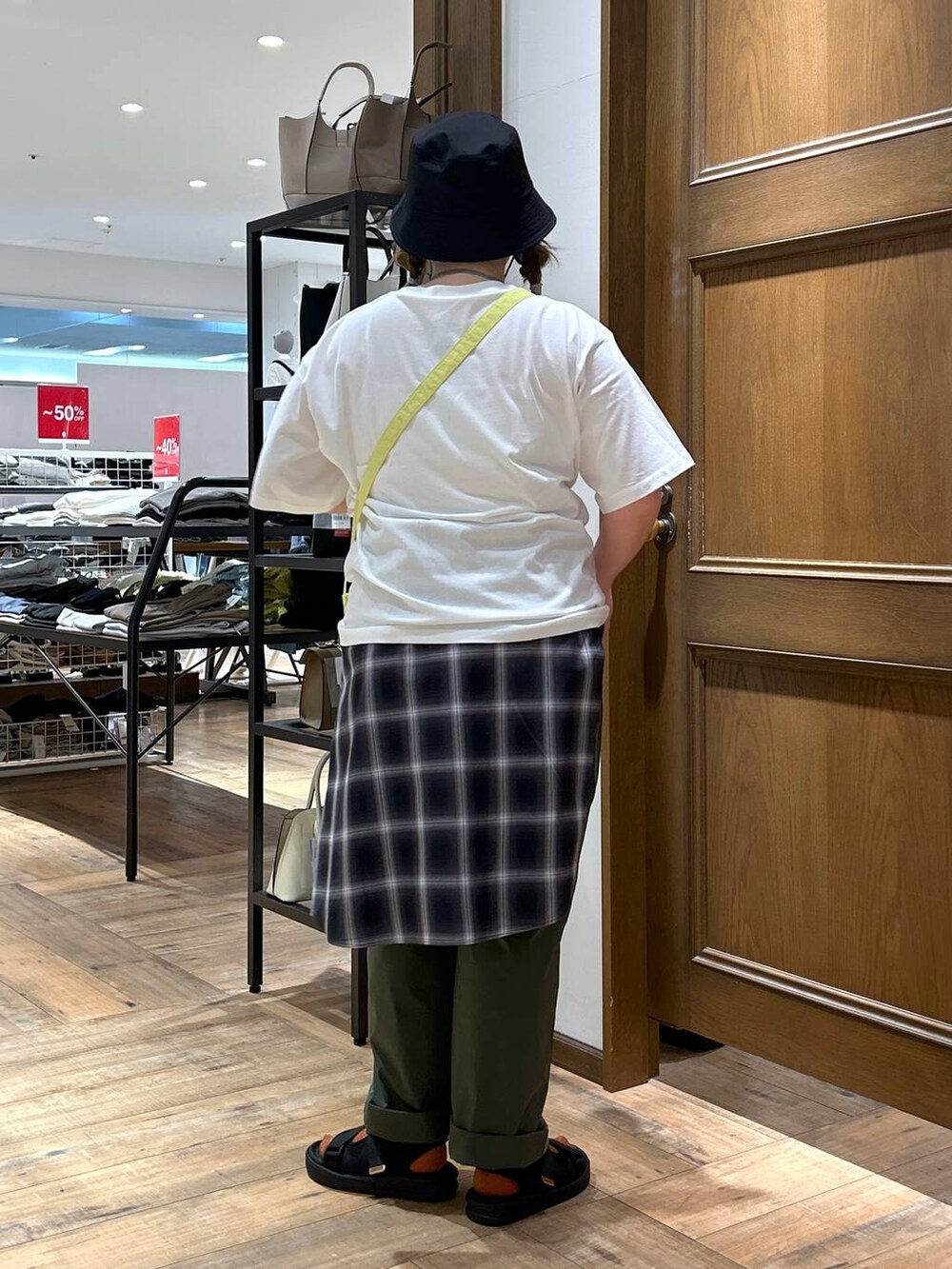 ブラック系のシャツ/ブラウス、グリーン系のその他パンツ、イエロー系のショルダーバッグを着用したレディースの春コーディネートの6枚目の写真