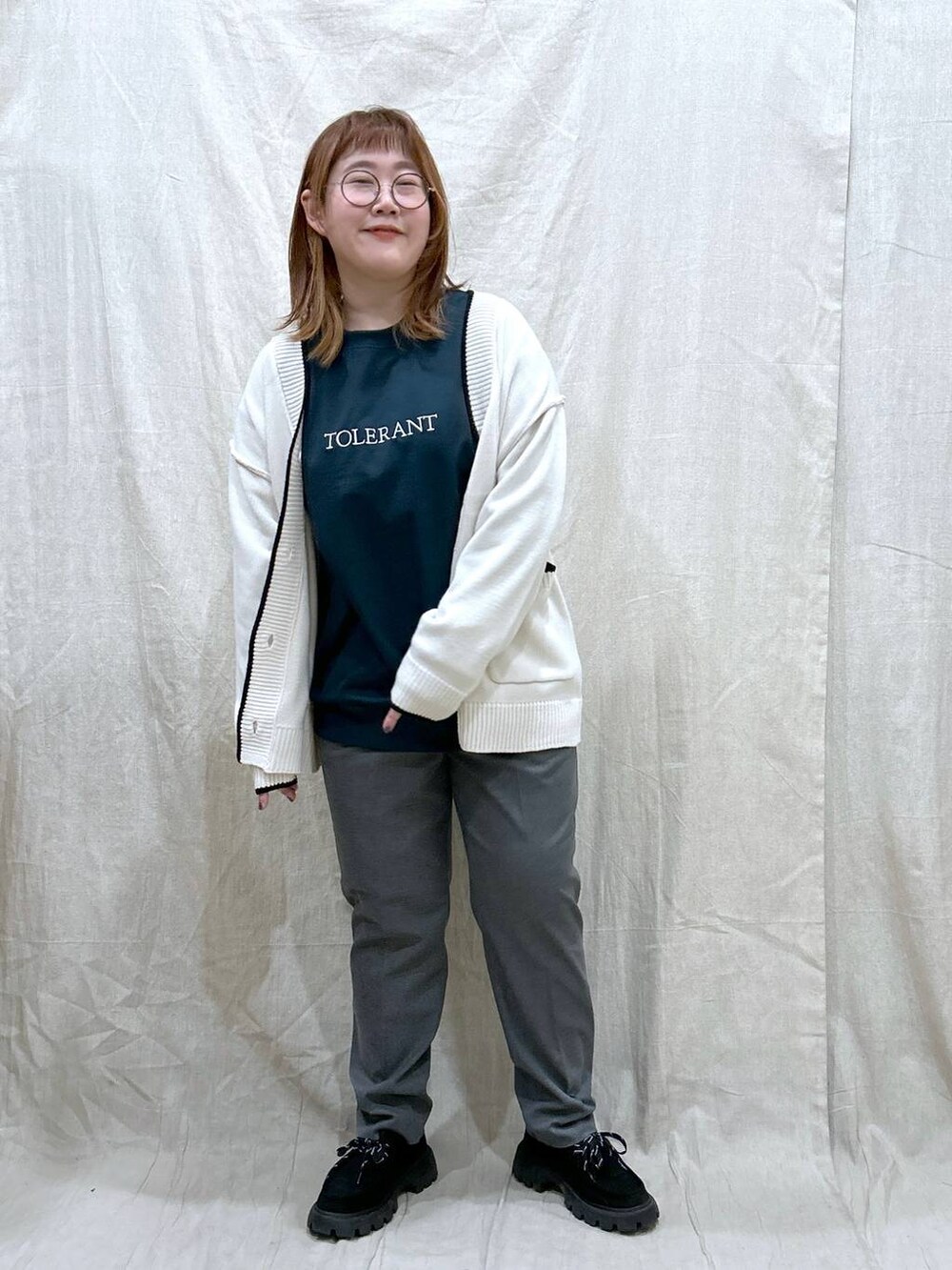 グレー系のその他パンツ、グリーン系のTシャツ/カットソー、ホワイト系のカーディガン/ボレロを着用したレディースの秋コーディネートの4枚目の写真