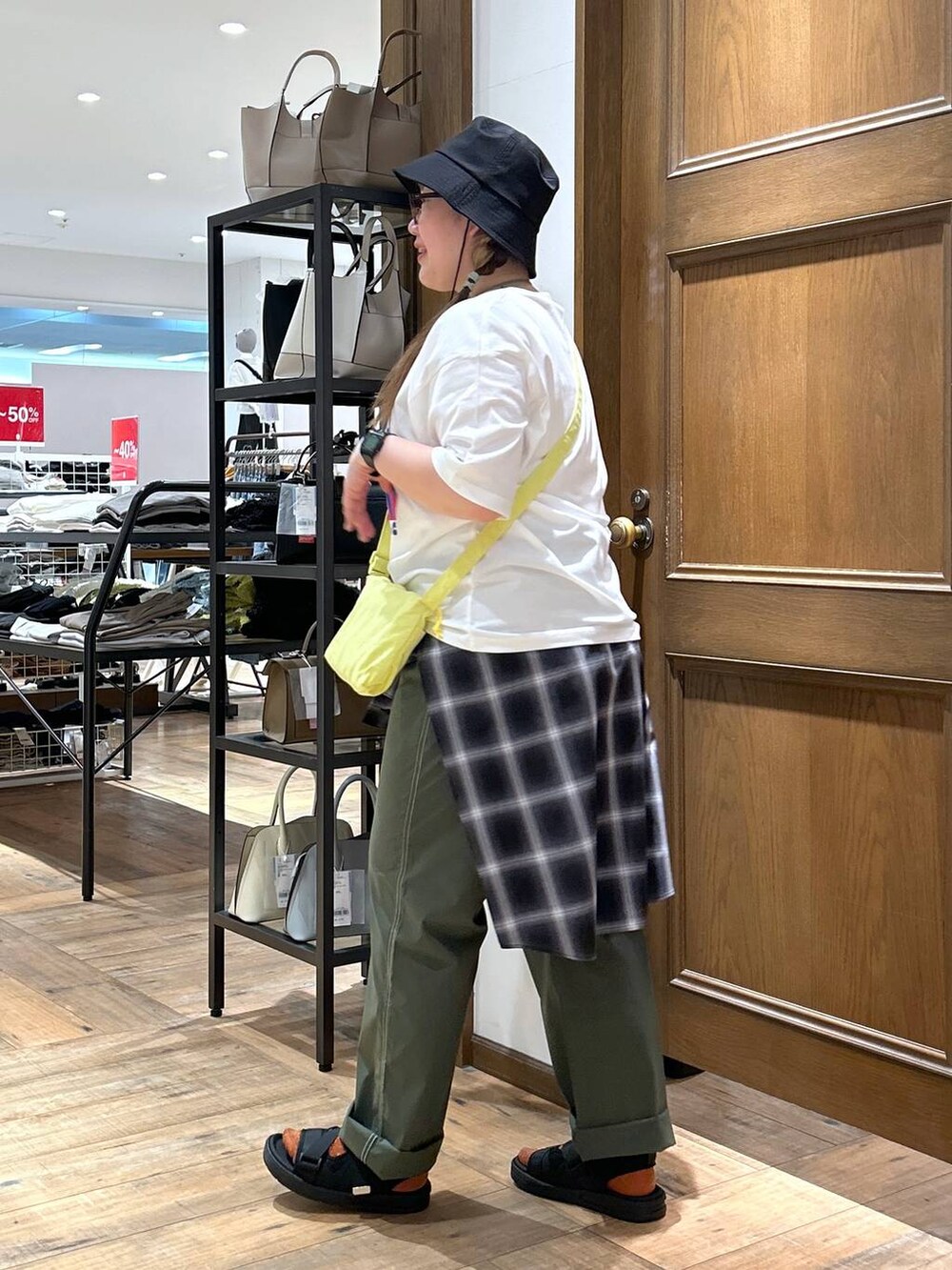 ブラック系のシャツ/ブラウス、グリーン系のその他パンツ、イエロー系のショルダーバッグを着用したレディースの春コーディネートの5枚目の写真