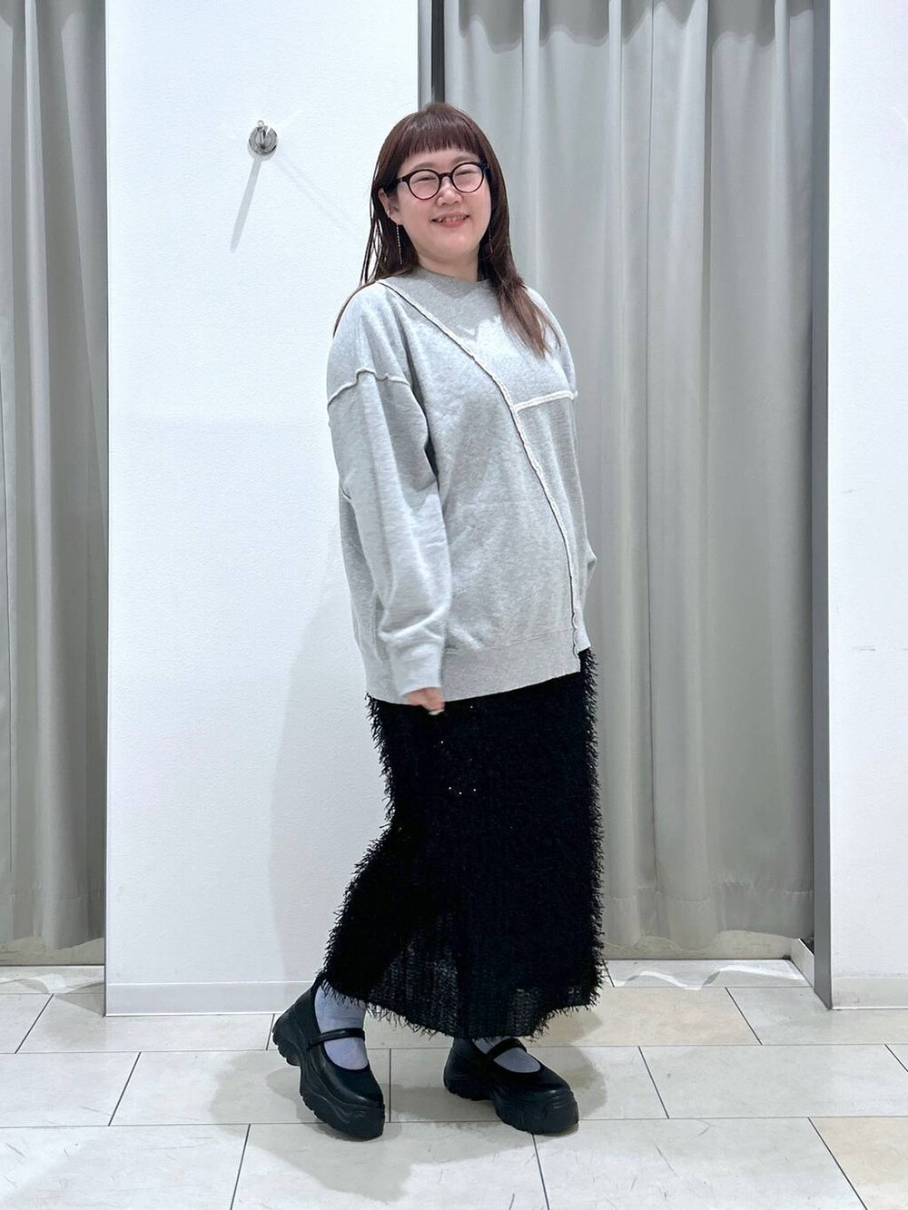 ブラック系のスニーカー、グレー系のスウェット、ブラック系のスカートを着用したレディースの秋コーディネートの5枚目の写真