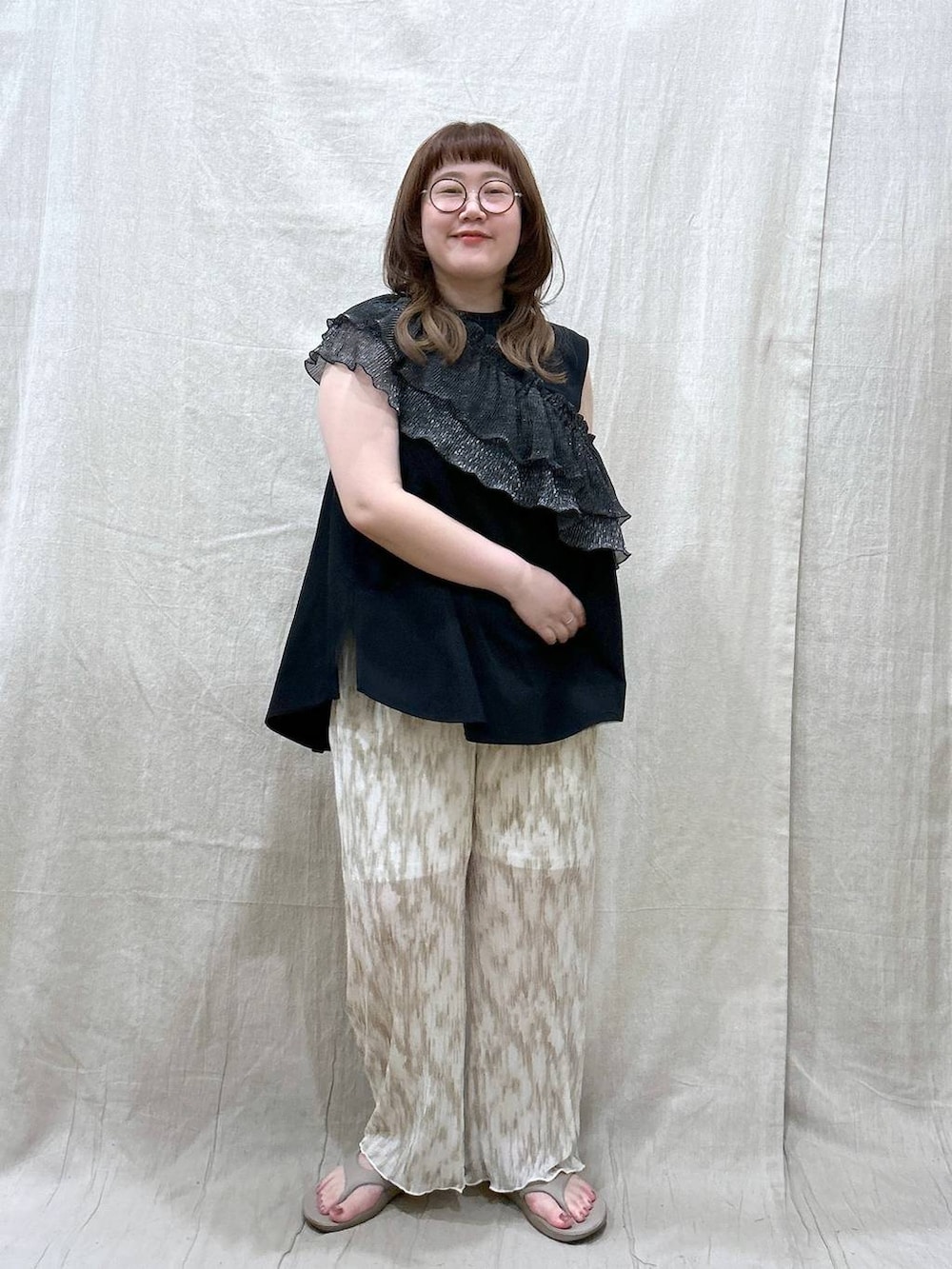 ベージュ系のその他パンツ、ベージュ系のサンダル、ブラック系のTシャツ/カットソーを着用したレディースの夏コーディネートの2枚目の写真