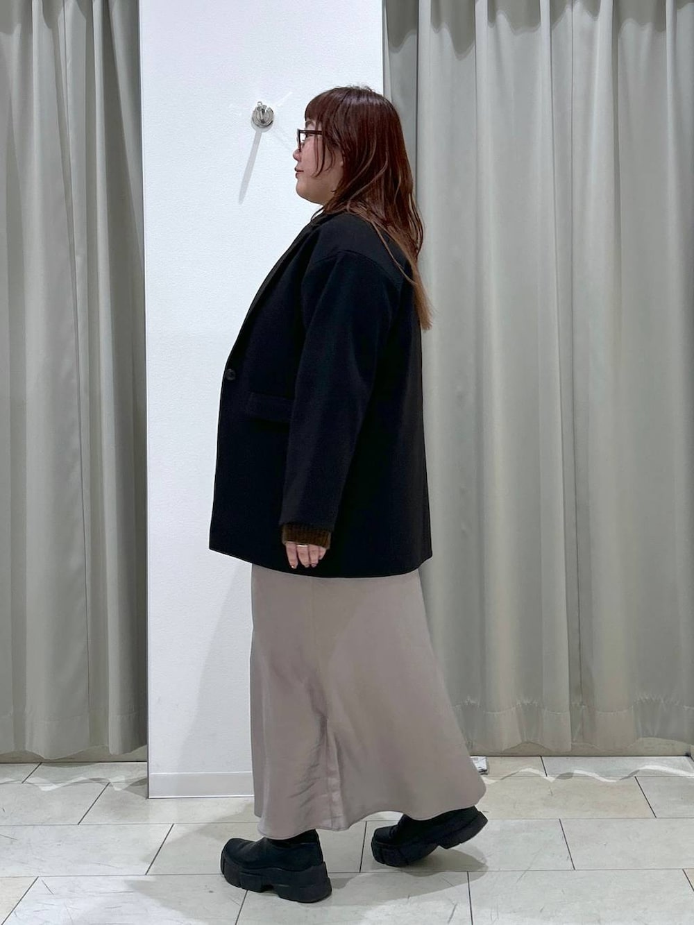 ブラック系のテーラードジャケット、グレー系のスカート、ブラウン系のショルダーバッグを着用したレディースの冬コーディネートの3枚目の写真