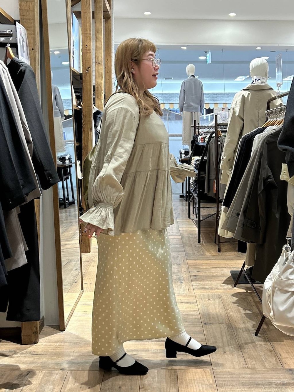 ベージュ系のスカート、ホワイト系のキャミソール、ブラック系のパンプスを着用したレディースの春コーディネートの7枚目の写真