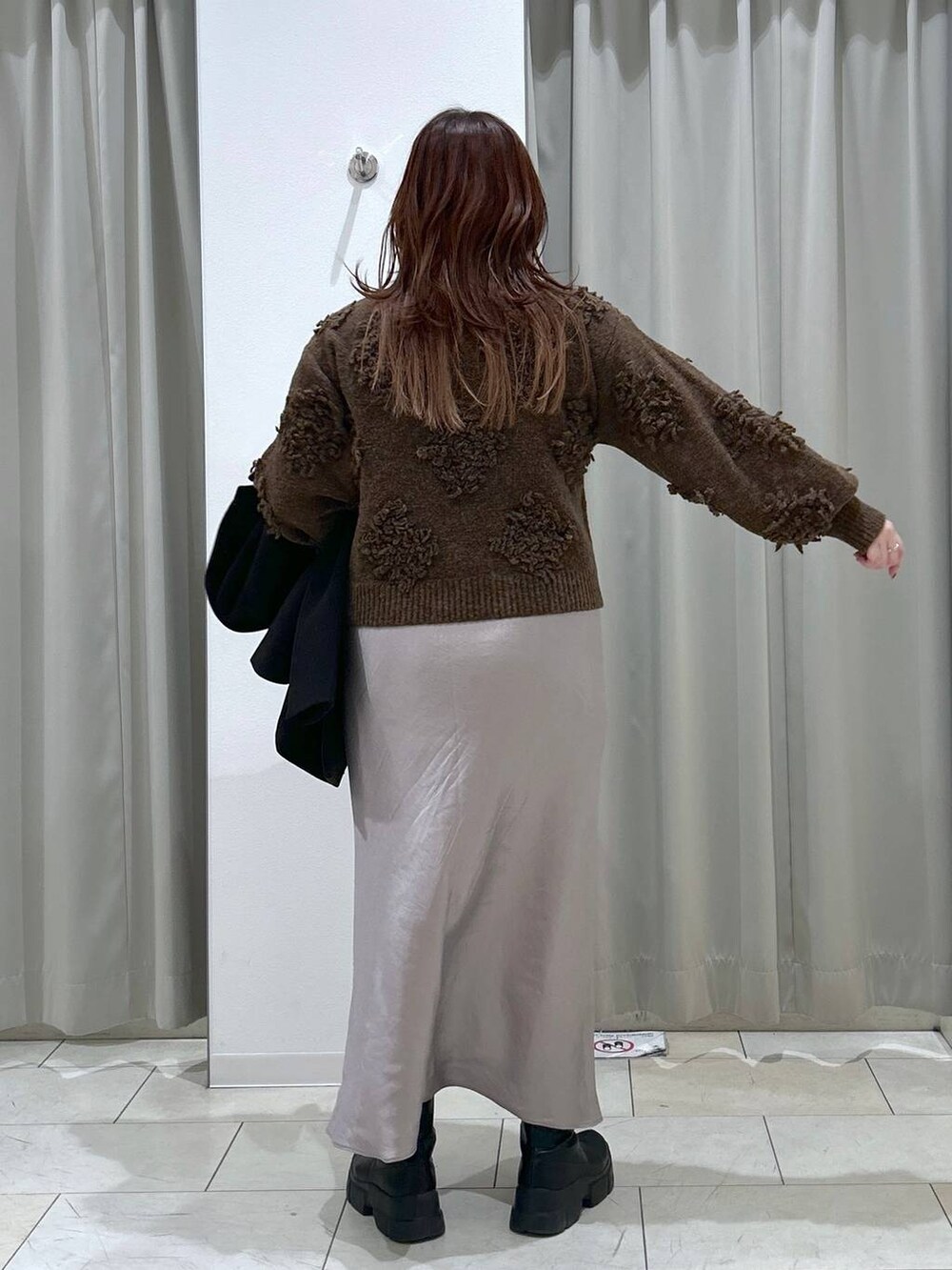 ブラック系のテーラードジャケット、グレー系のスカート、ブラウン系のショルダーバッグを着用したレディースの冬コーディネートの9枚目の写真