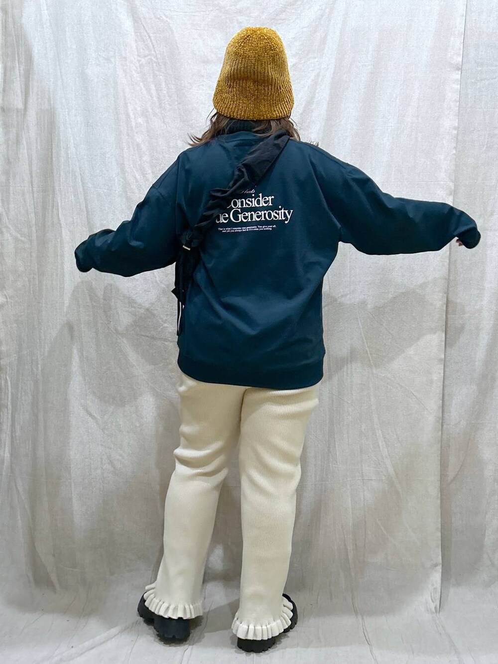 グリーン系のTシャツ/カットソー、ブラック系のモカシン/デッキシューズ、ブラック系のショルダーバッグを着用したレディースの秋コーディネートの6枚目の写真