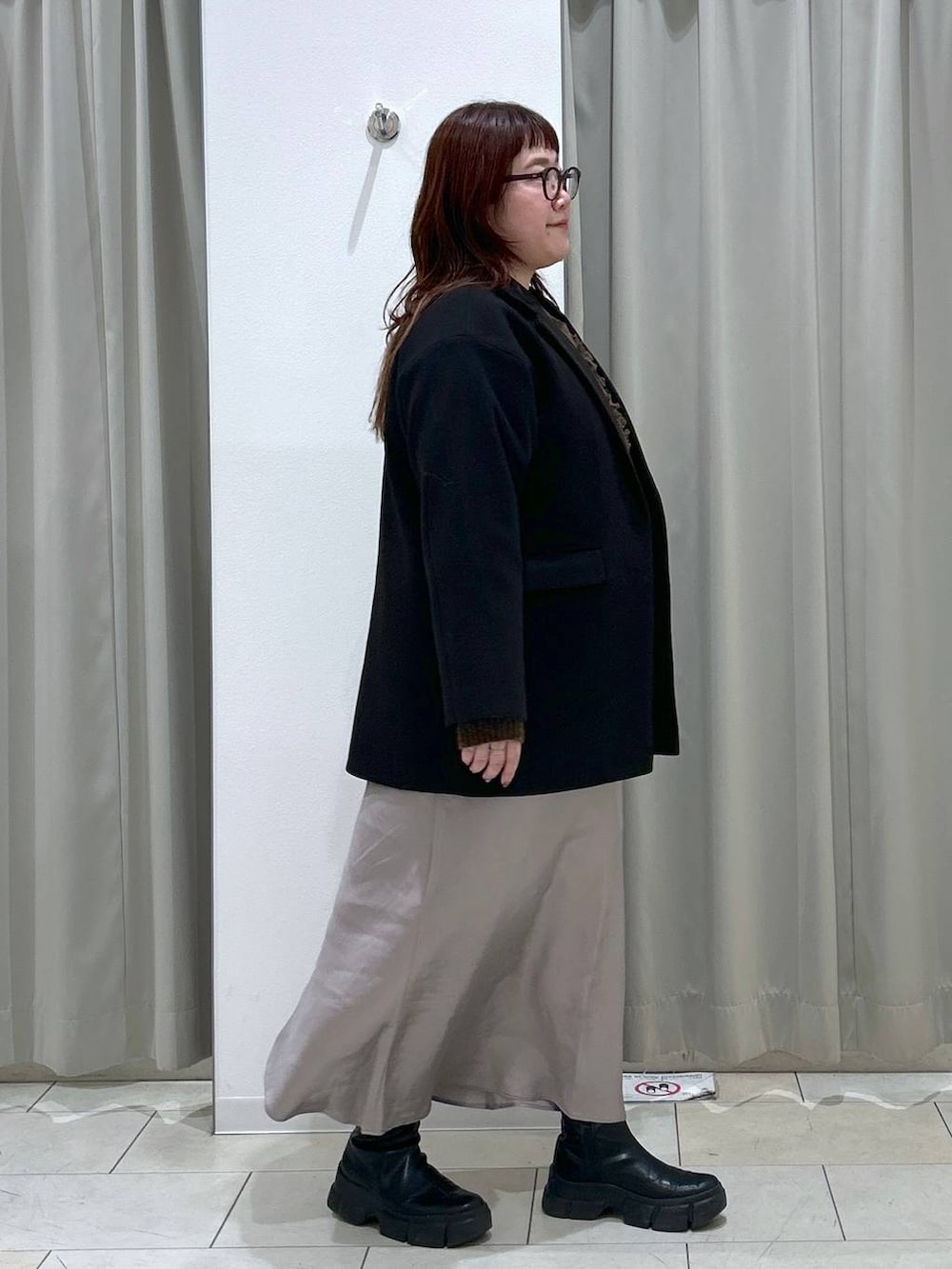 ブラック系のテーラードジャケット、グレー系のスカート、ブラウン系のショルダーバッグを着用したレディースの冬コーディネートの5枚目の写真