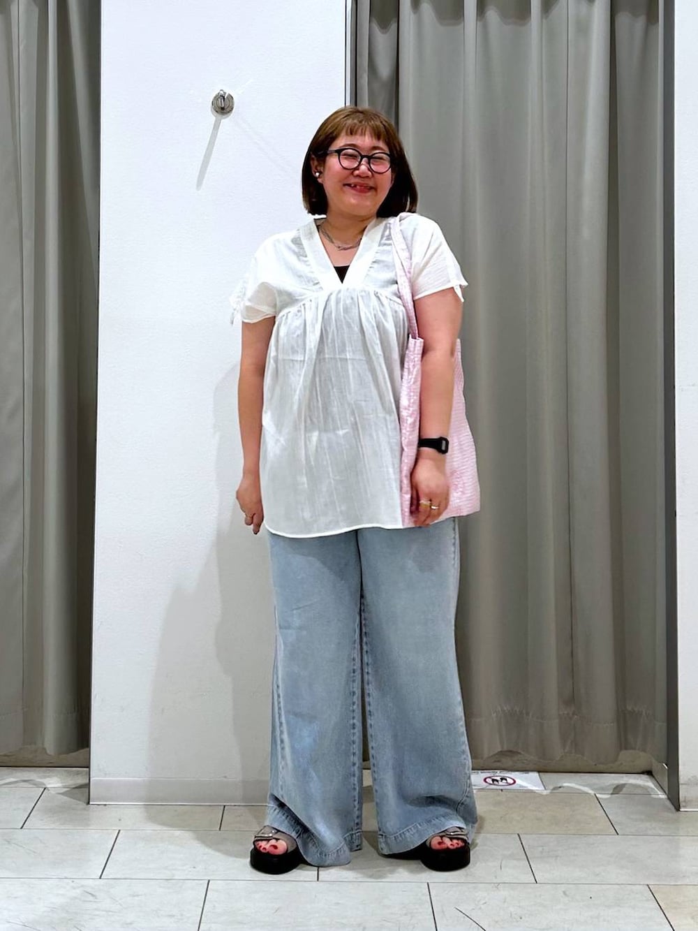 その他のトートバッグ、ブルー系のデニムパンツ、ブラウン系のタンクトップを着用したレディースの春コーディネートの2枚目の写真