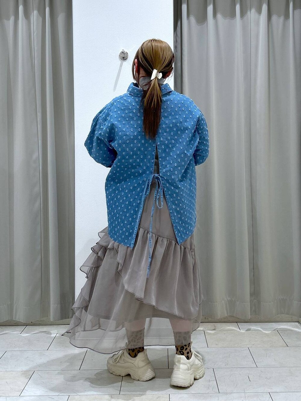 グレー系のニット/セーター、グレー系のスカート、ホワイト系のスニーカーを着用したレディースの冬コーディネートの5枚目の写真