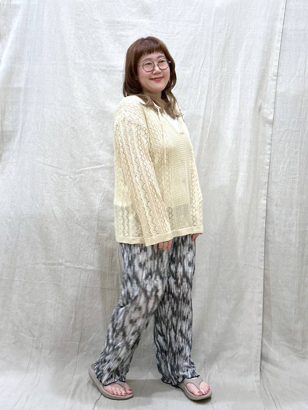 ホワイト系のニット/セーター、ブラック系のその他パンツ、ホワイト系のタンクトップを着用したレディースの夏コーディネートの7枚目の写真