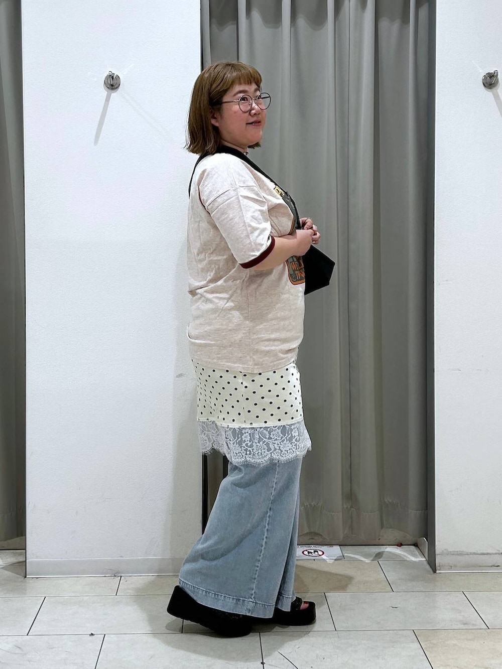 ブルー系のデニムパンツ、ブラック系のサンダル、ブラック系のショルダーバッグを着用したレディースの春コーディネートの6枚目の写真