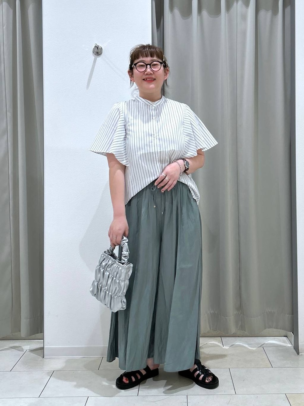 ブラック系のスニーカー、グリーン系のその他パンツ、グレー系のショルダーバッグを着用したレディースの春コーディネートの2枚目の写真