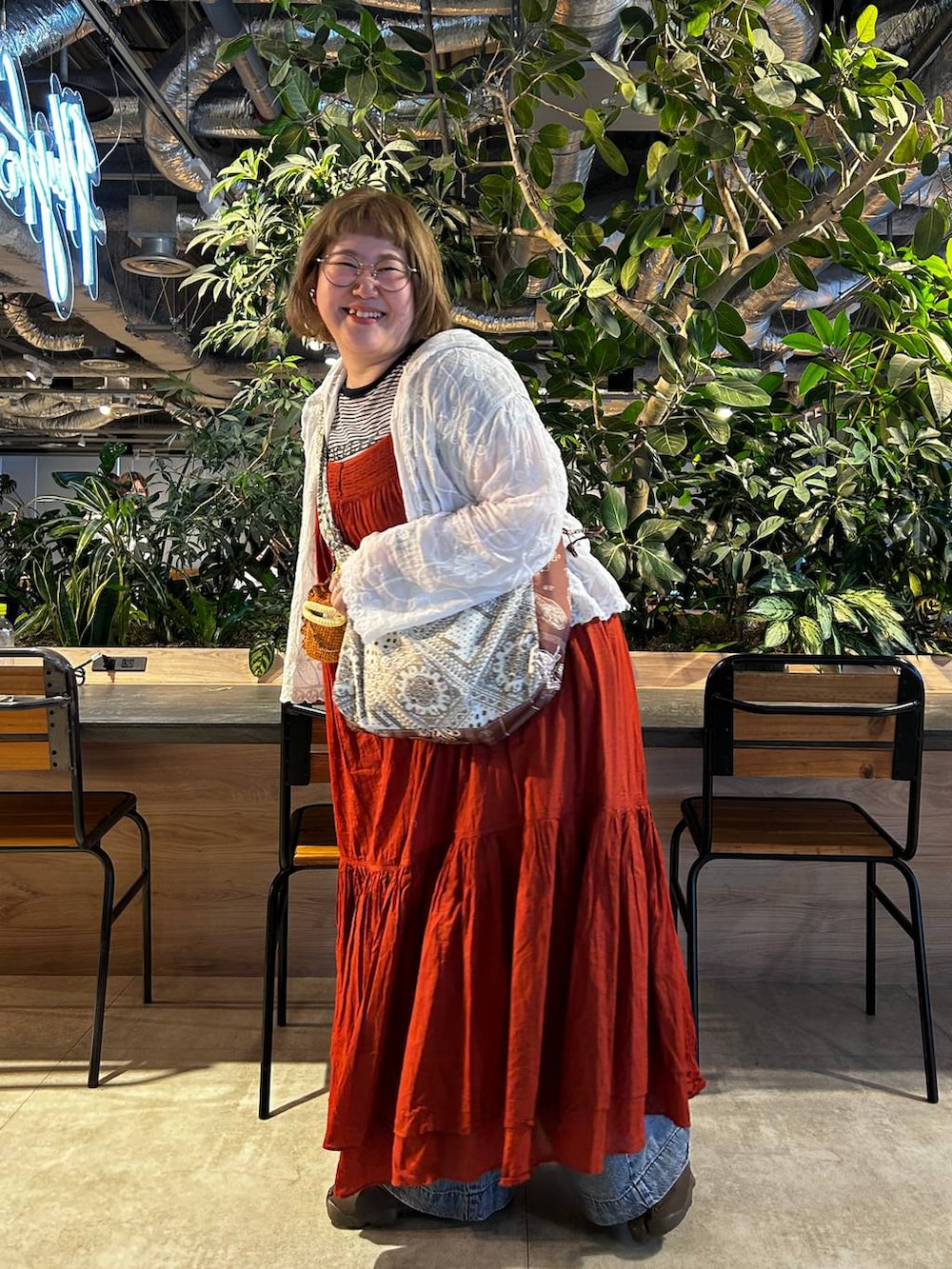 ブルー系のデニムパンツ、オレンジ系のワンピースを着用したレディースの夏コーディネートの5枚目の写真