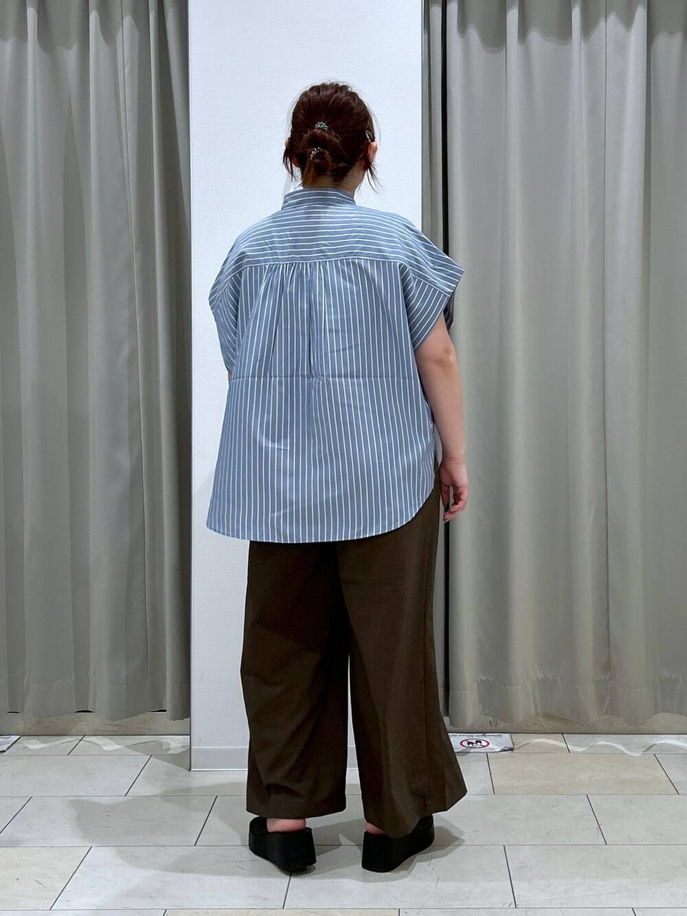 ブラック系のサンダル、ホワイト系のショルダーバッグ、ブラウン系のスラックスを着用したレディースの夏コーディネートの4枚目の写真