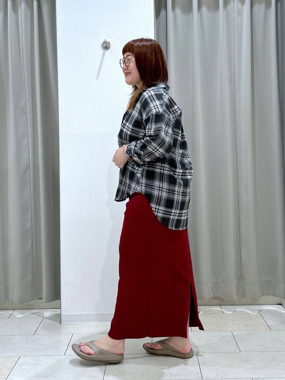 レッド系のスカート、ホワイト系のキャミソール、ベージュ系のサンダルを着用したレディースの夏コーディネートの5枚目の写真