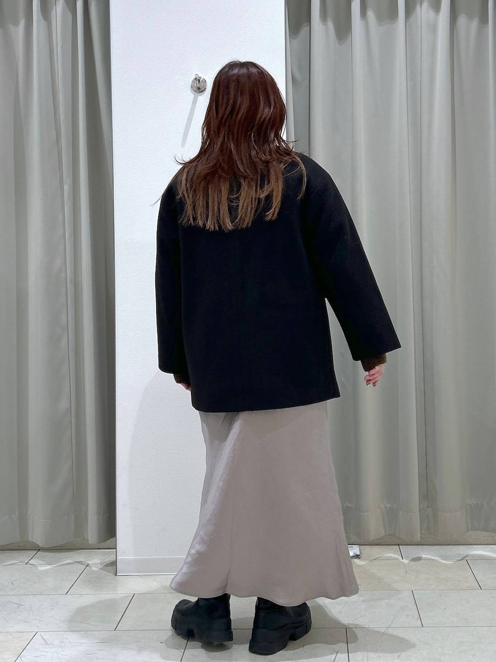 ブラック系のテーラードジャケット、グレー系のスカート、ブラウン系のショルダーバッグを着用したレディースの冬コーディネートの4枚目の写真