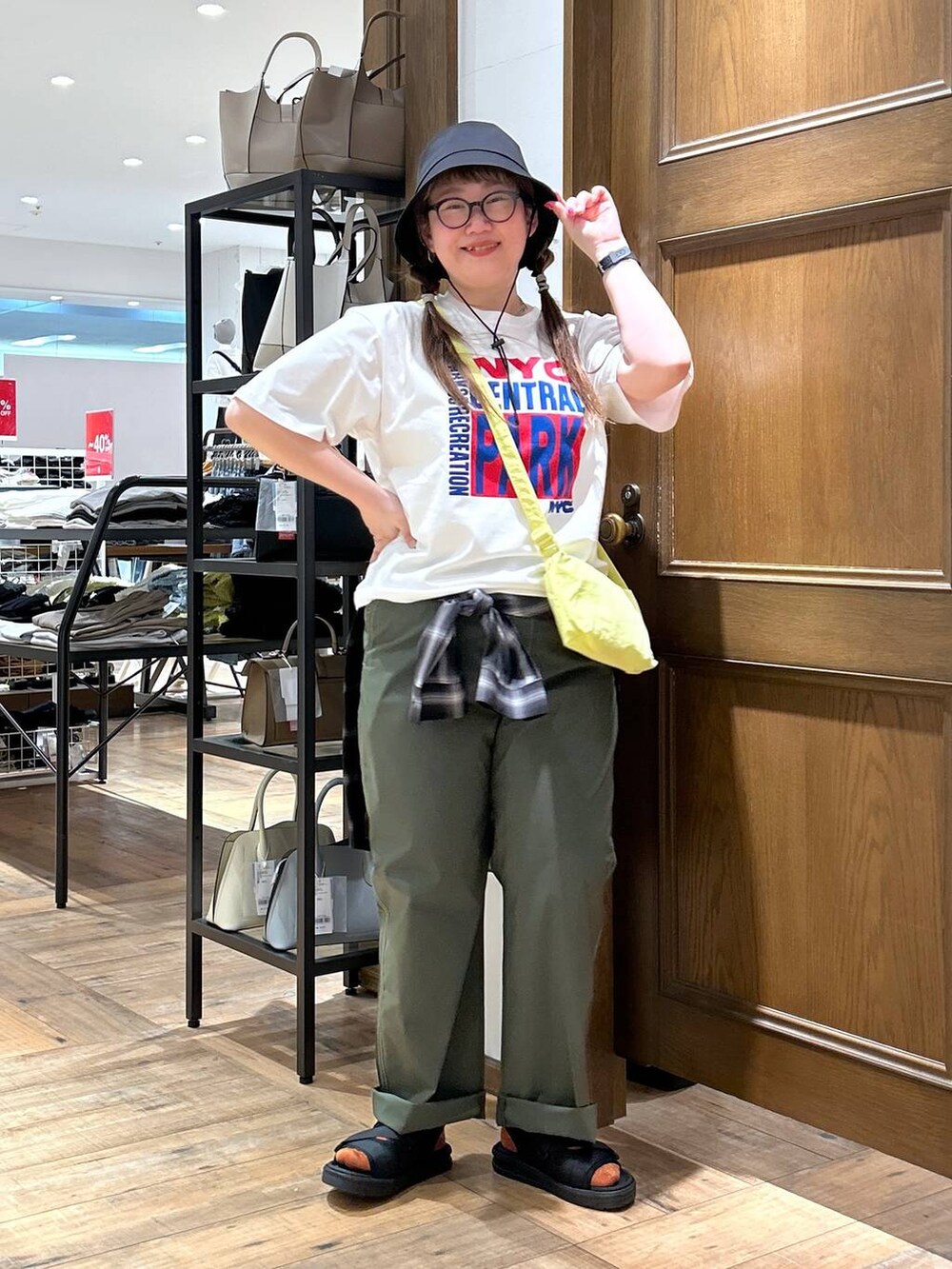 ブラック系のシャツ/ブラウス、グリーン系のその他パンツ、イエロー系のショルダーバッグを着用したレディースの春コーディネートの4枚目の写真