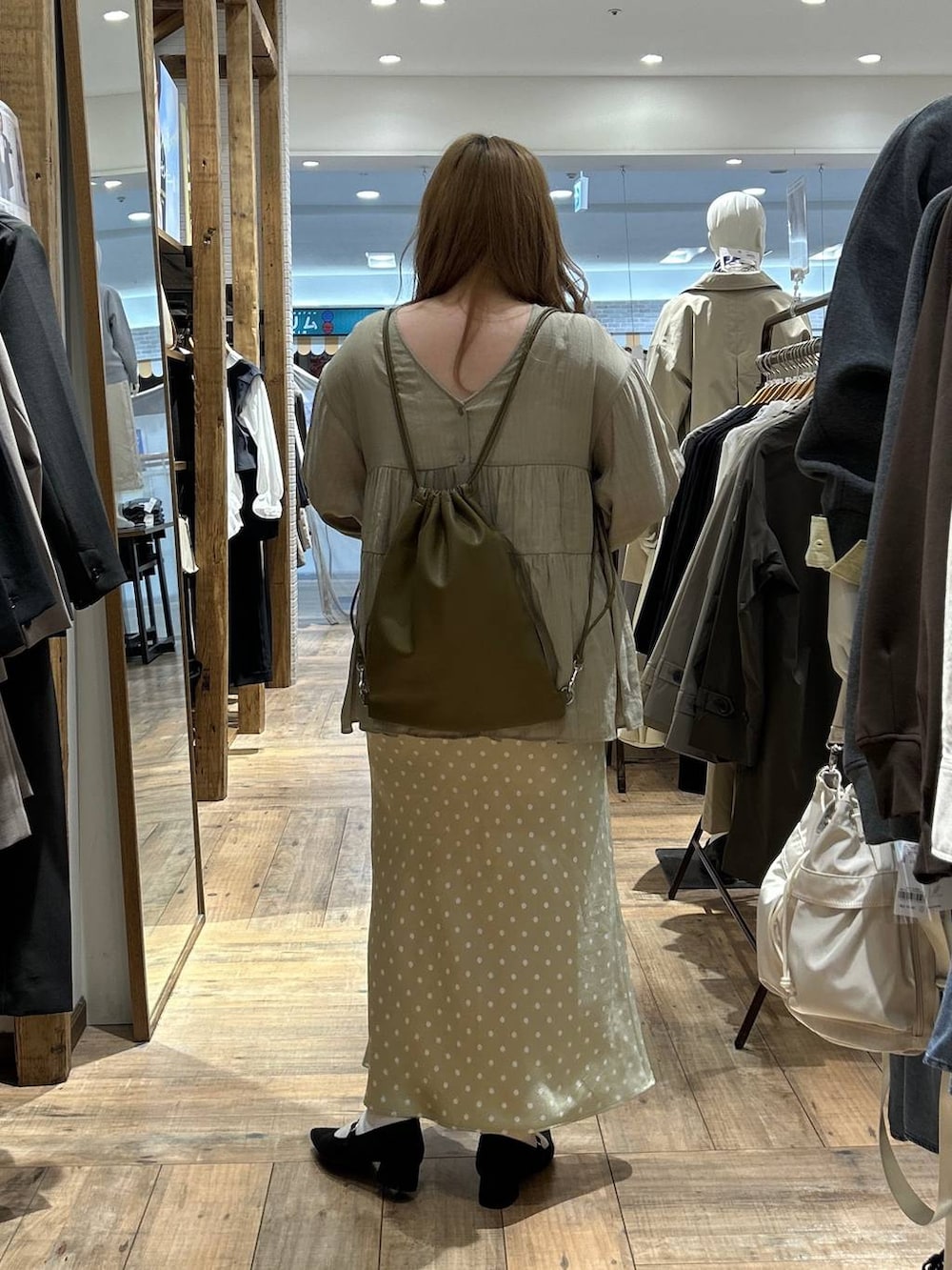 ベージュ系のスカート、ホワイト系のキャミソール、ブラック系のパンプスを着用したレディースの春コーディネートの6枚目の写真