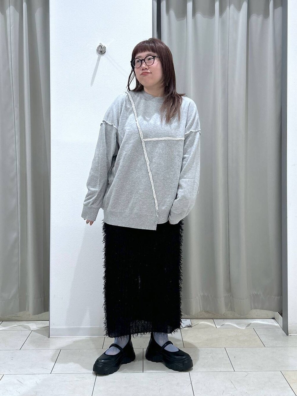 ブラック系のスニーカー、グレー系のスウェット、ブラック系のスカートを着用したレディースの秋コーディネートの2枚目の写真