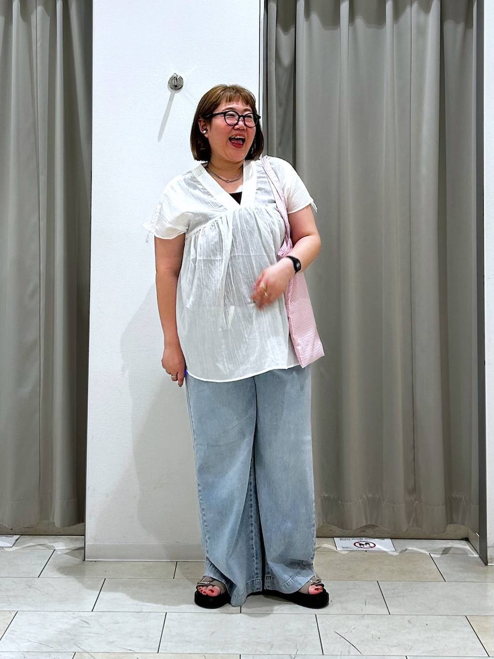 その他のトートバッグ、ブルー系のデニムパンツ、ブラウン系のタンクトップを着用したレディースの春コーディネートの4枚目の写真