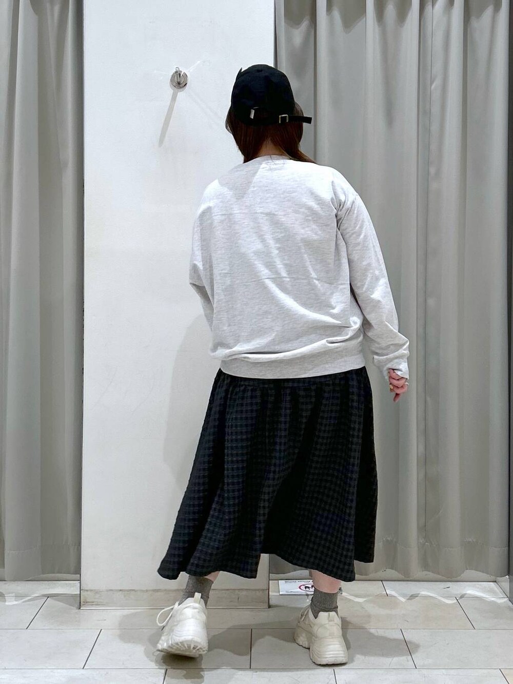 ブラック系のワンピース、ホワイト系のスニーカー、グレー系のスウェットを着用したレディースの冬コーディネートの7枚目の写真