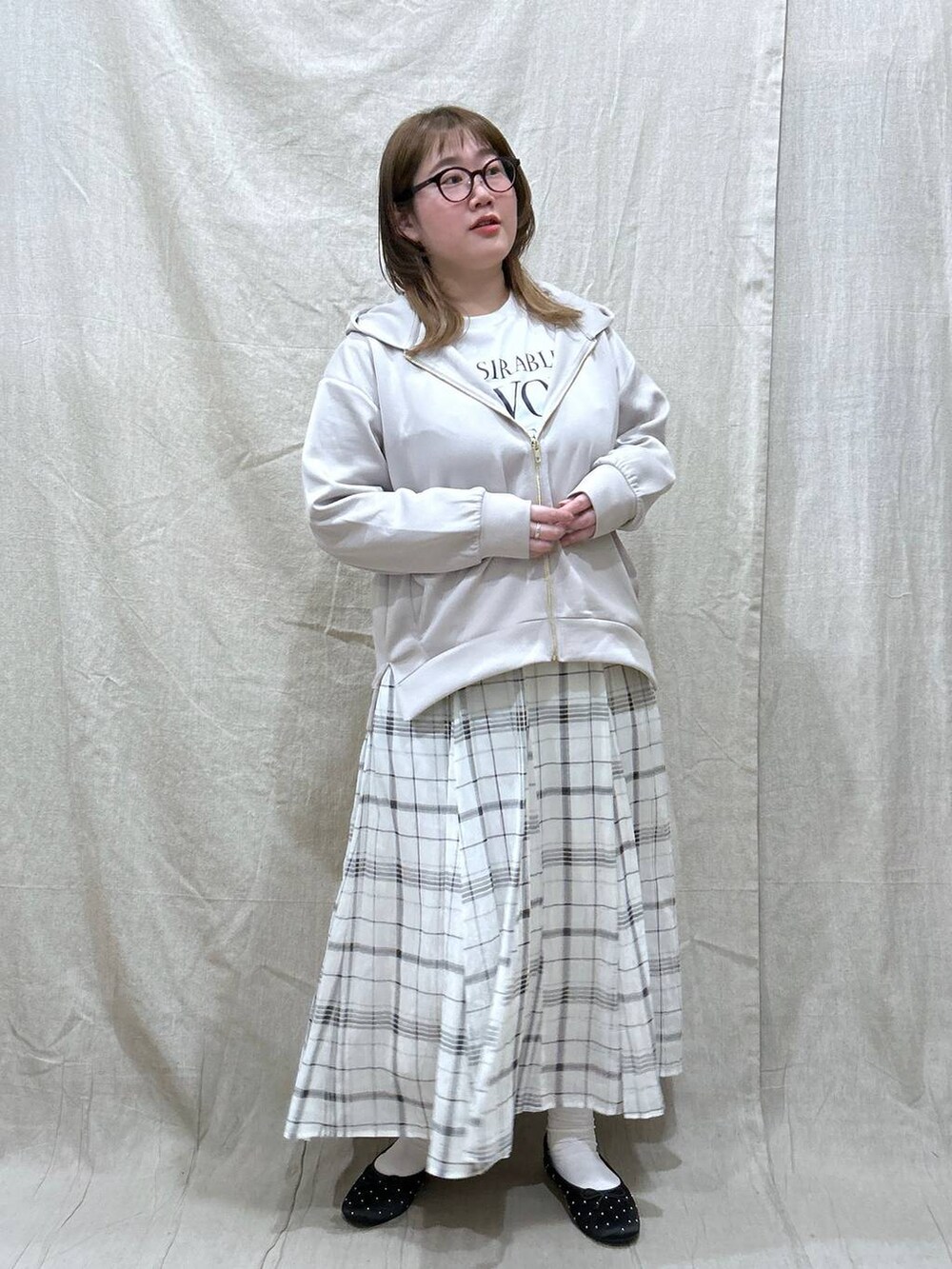 ベージュ系のスカート、ホワイト系のTシャツ/カットソー、ベージュ系のパーカーを着用したレディースの冬コーディネートの2枚目の写真