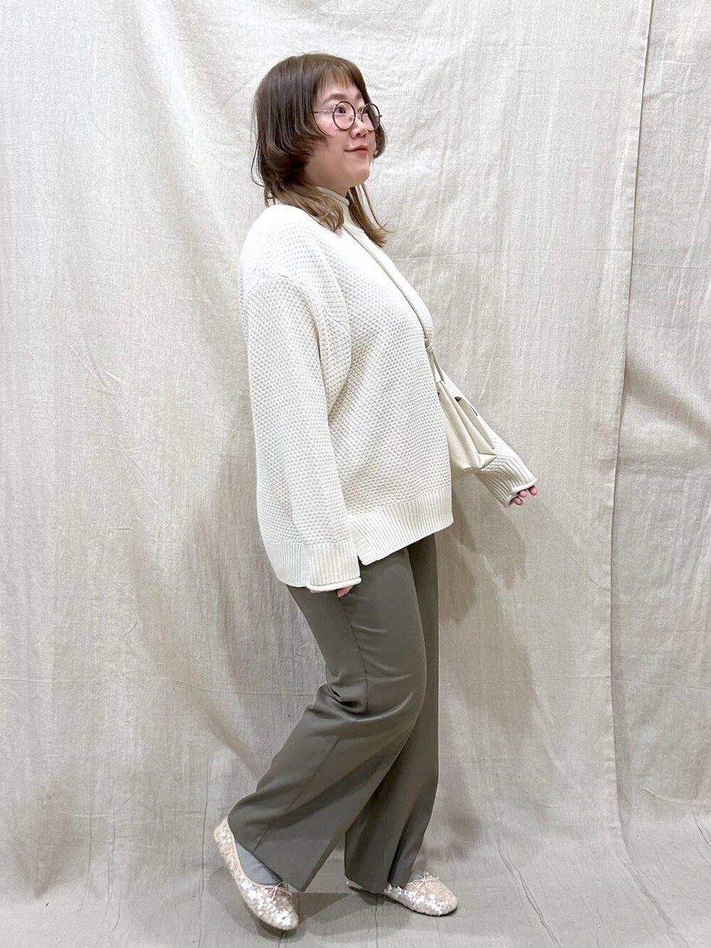 ホワイト系のショルダーバッグ、グリーン系のその他パンツ、ホワイト系のニット/セーターを着用したレディースの冬コーディネートの4枚目の写真