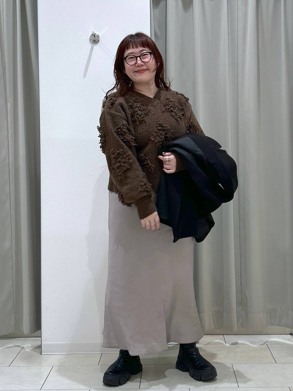 ブラック系のテーラードジャケット、グレー系のスカート、ブラウン系のショルダーバッグを着用したレディースの冬コーディネートの7枚目の写真
