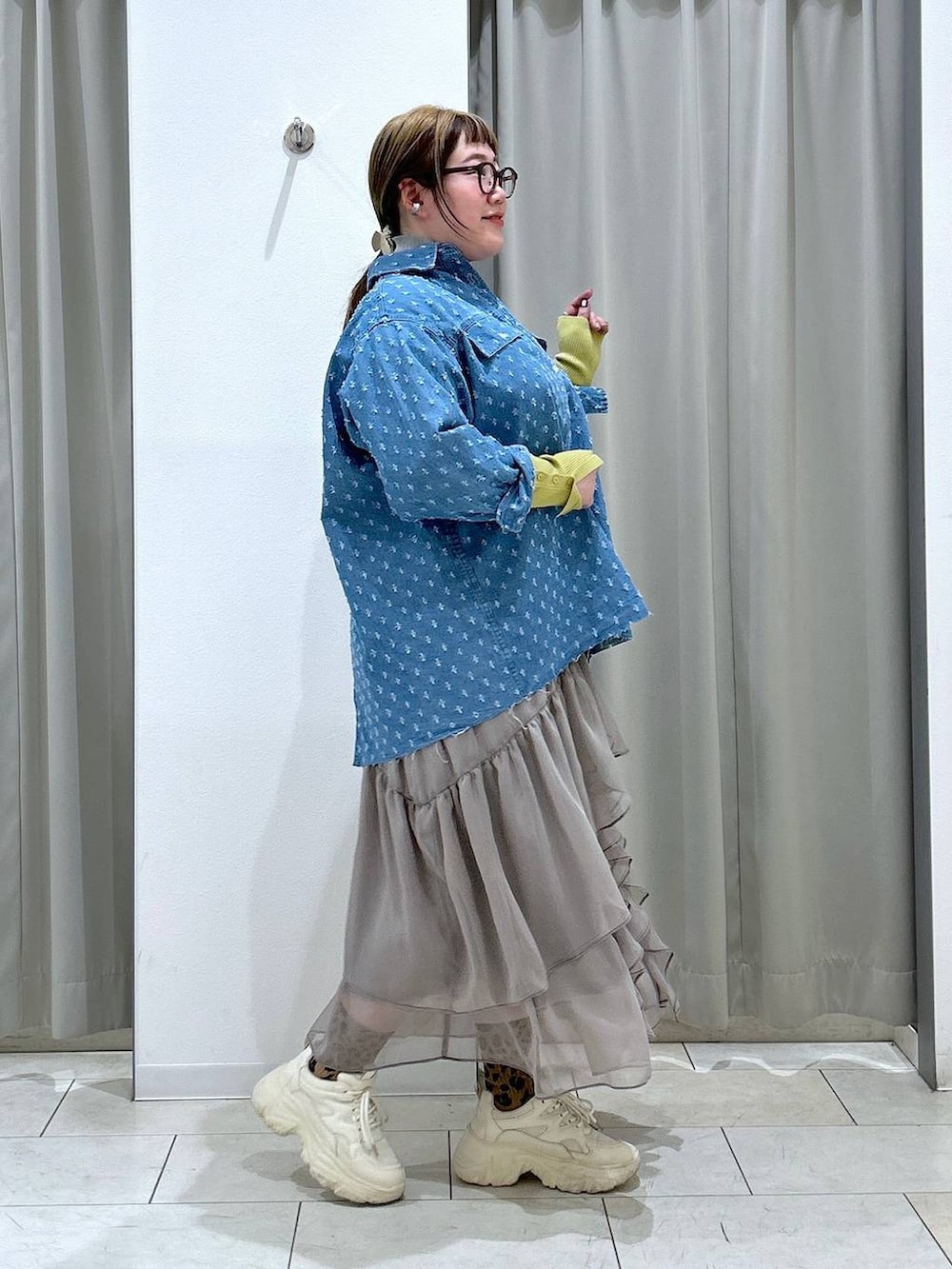 グレー系のニット/セーター、グレー系のスカート、ホワイト系のスニーカーを着用したレディースの冬コーディネートの6枚目の写真