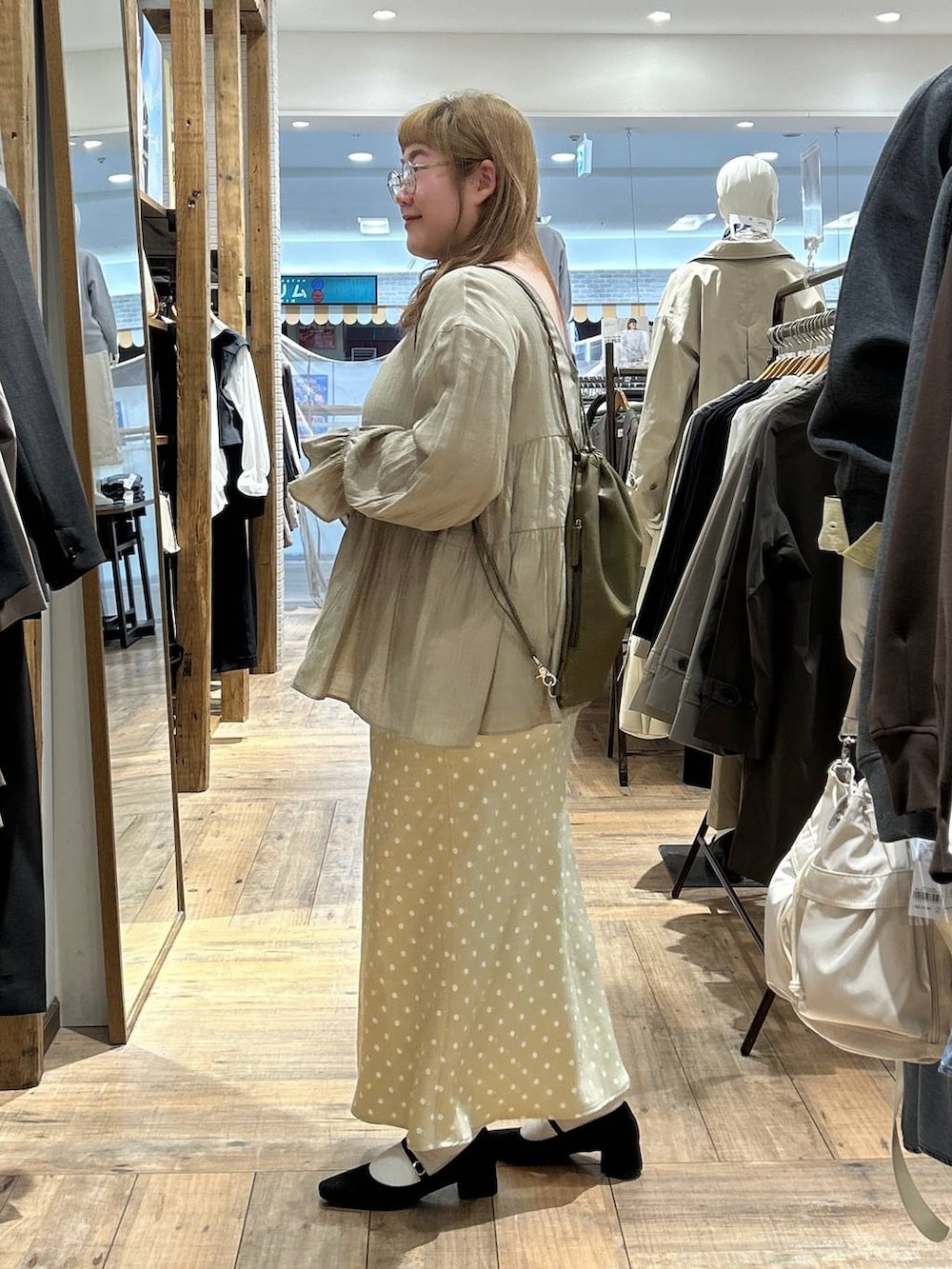 ベージュ系のスカート、ホワイト系のキャミソール、ブラック系のパンプスを着用したレディースの春コーディネートの5枚目の写真