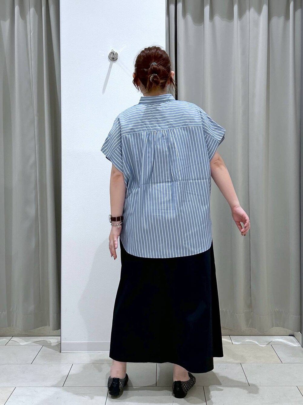 ブラック系のスカート、ブラック系のパンプス、ブルー系のシャツ/ブラウスを着用したレディースの夏コーディネートの5枚目の写真