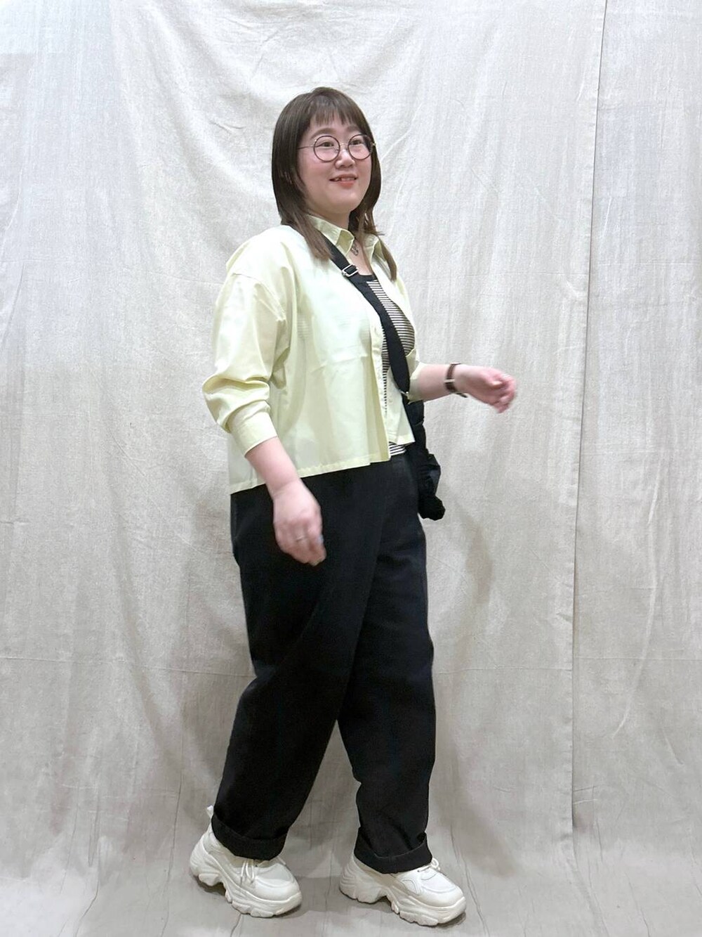 ブラック系のタンクトップ、ブラック系のデニムパンツ、イエロー系のシャツ/ブラウスを着用したレディースの春コーディネートの4枚目の写真