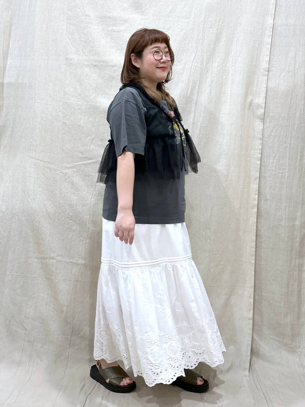 ホワイト系のスカート、グレー系のTシャツ/カットソー、グリーン系のサンダルを着用したレディースの夏コーディネートの6枚目の写真