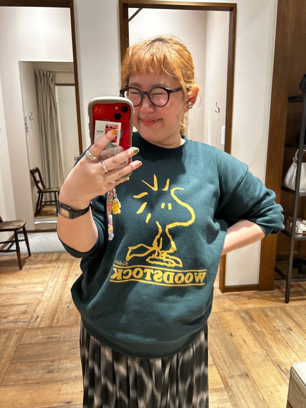 ブラック系のブーツ、グリーン系のスウェット、ブラック系のスカートを着用したレディースの秋コーディネートの3枚目の写真