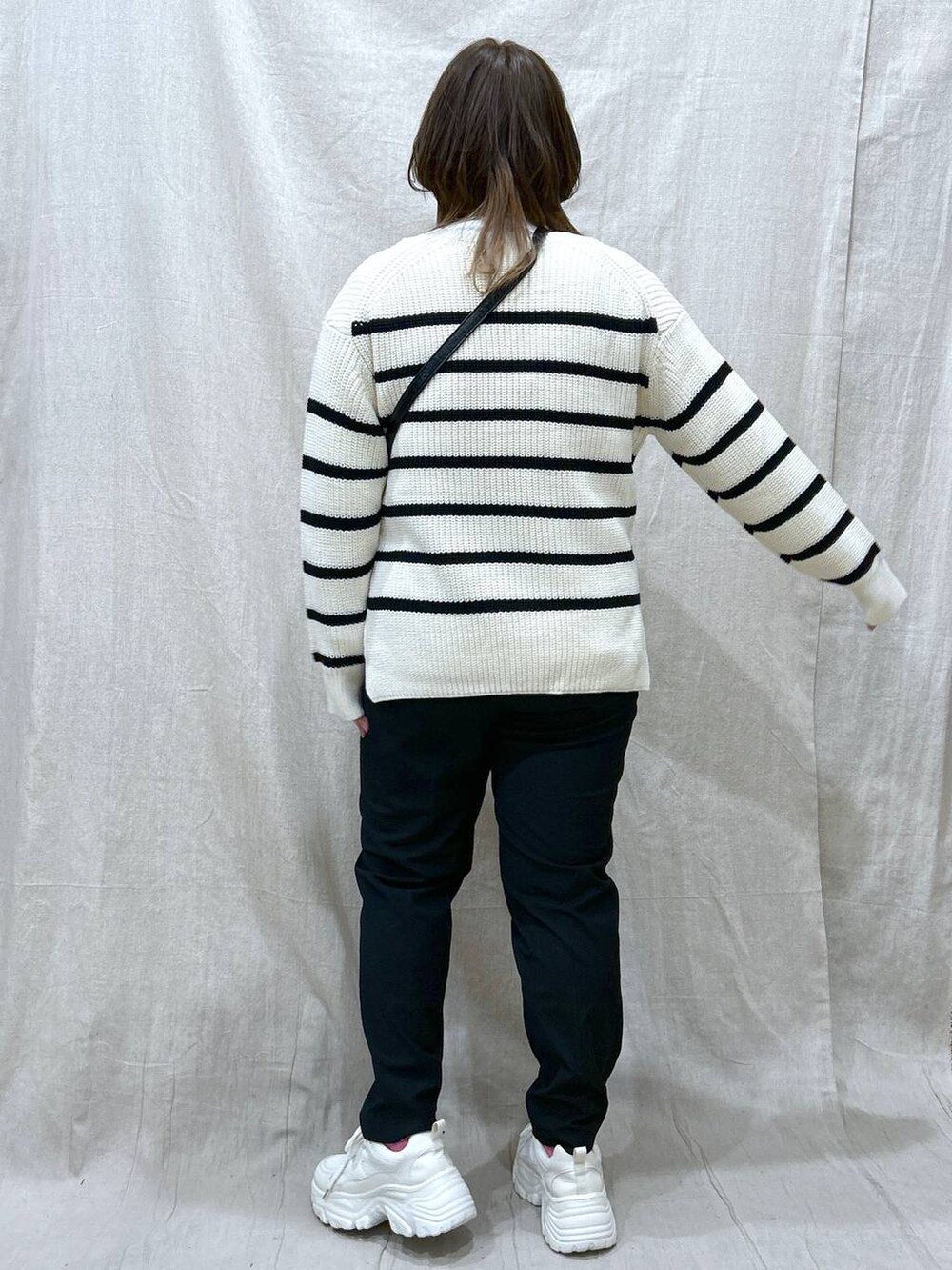 ホワイト系のニット/セーター、ホワイト系のTシャツ/カットソー、ブラック系のその他パンツを着用したレディースの冬コーディネートの5枚目の写真