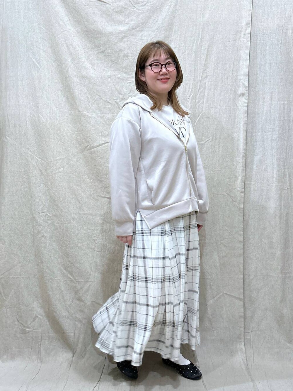 ベージュ系のスカート、ホワイト系のTシャツ/カットソー、ベージュ系のパーカーを着用したレディースの冬コーディネートの4枚目の写真