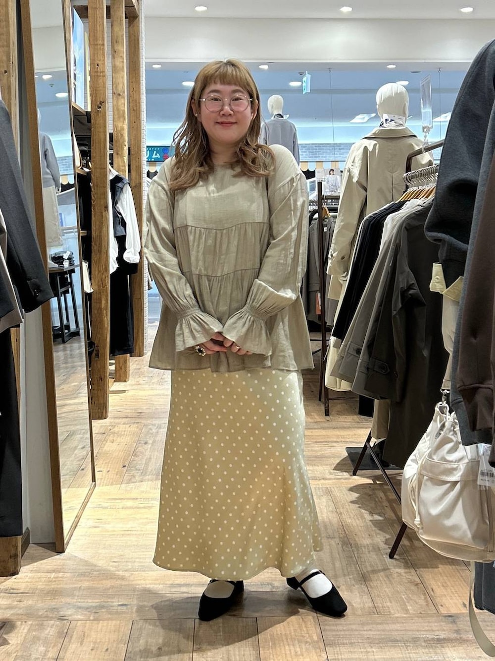 ベージュ系のスカート、ホワイト系のキャミソール、ブラック系のパンプスを着用したレディースの春コーディネートの3枚目の写真