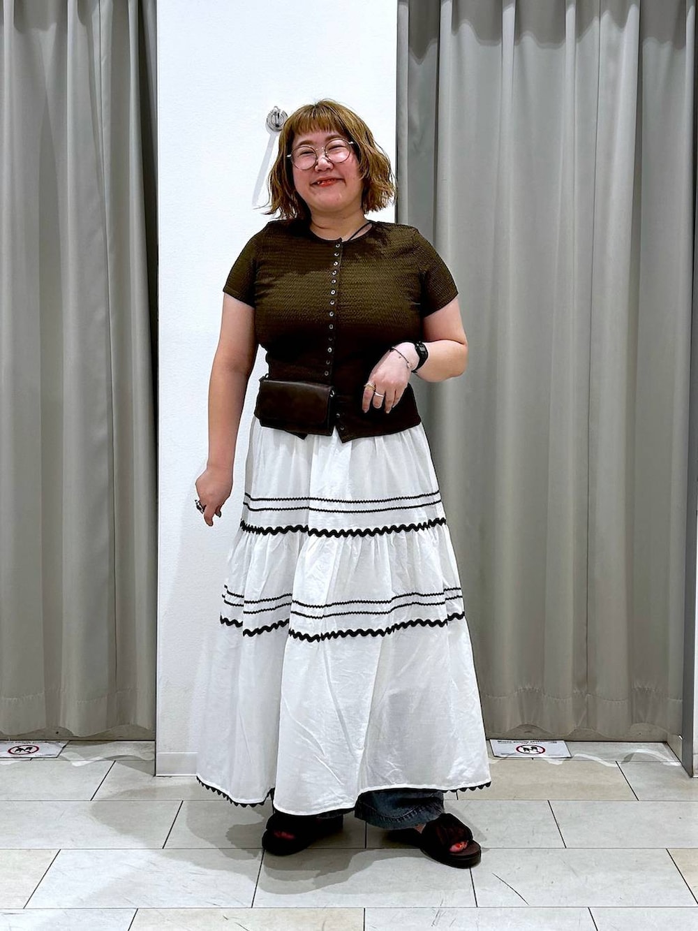 ブルー系のデニムパンツ、ブラウン系のボディバッグ/ウエストポーチ、ブラウン系のTシャツ/カットソーを着用したレディースの夏コーディネートの2枚目の写真