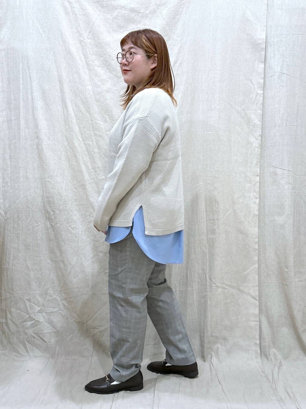 グレー系のその他パンツ、ブルー系のシャツ/ブラウス、ホワイト系のニット/セーターを着用したレディースの秋コーディネートの7枚目の写真