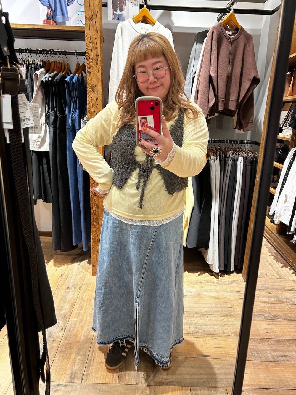 イエロー系のTシャツ/カットソー、ブルー系のデニムスカート、グレー系のベストを着用したレディースの春コーディネートの2枚目の写真