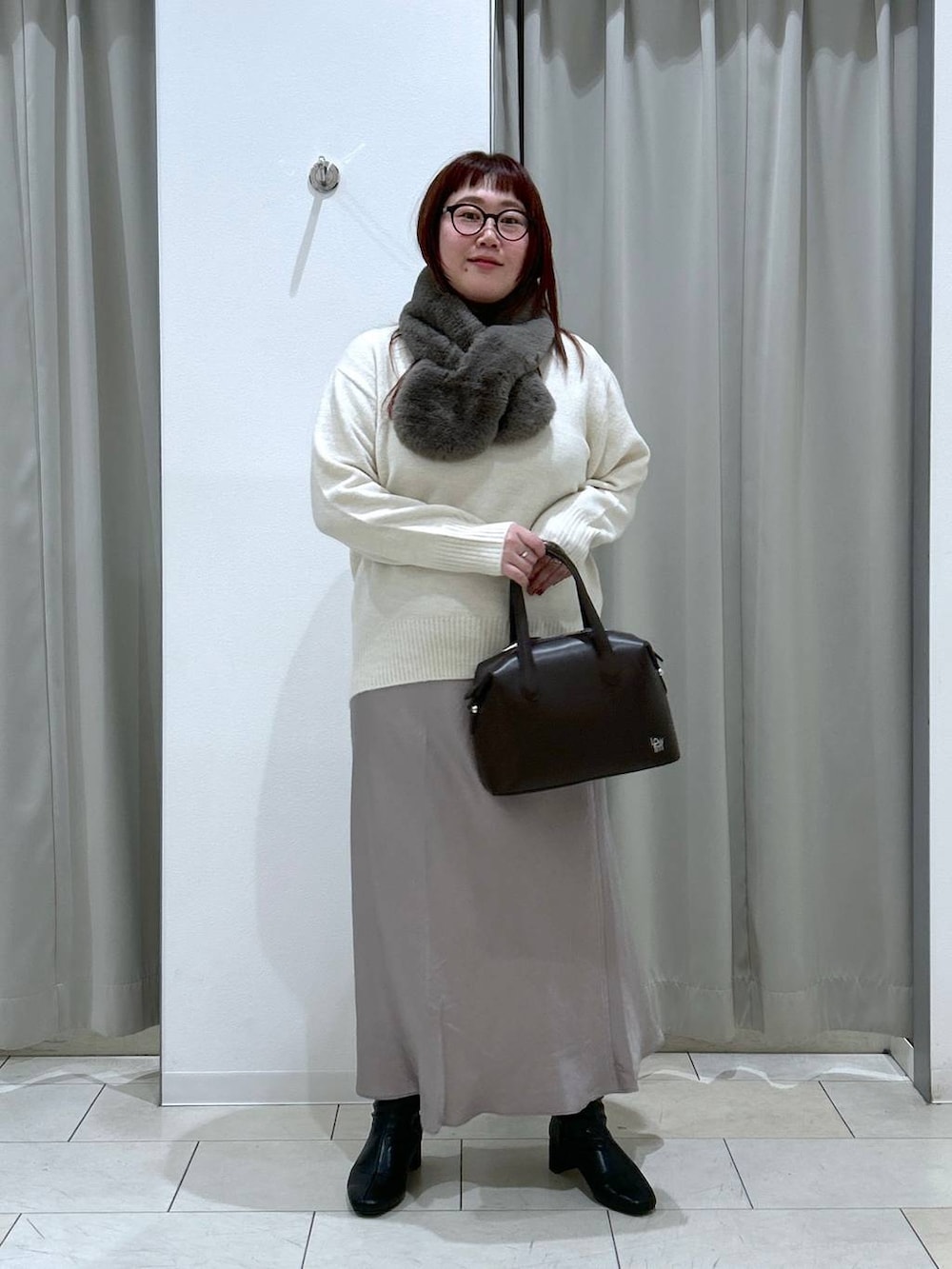ホワイト系のニット/セーター、ブラック系のブーツ、ブラウン系のショルダーバッグを着用したレディースの冬コーディネートの3枚目の写真