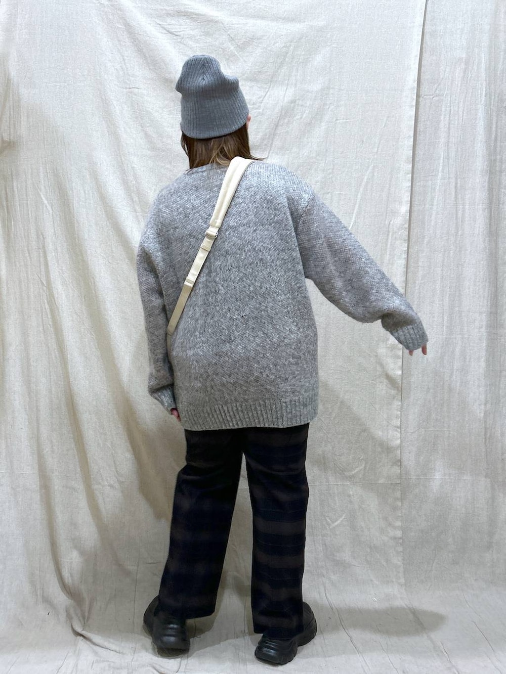 ホワイト系のショルダーバッグ、ブルー系のその他パンツ、ブラック系のブーツを着用したレディースの冬コーディネートの6枚目の写真