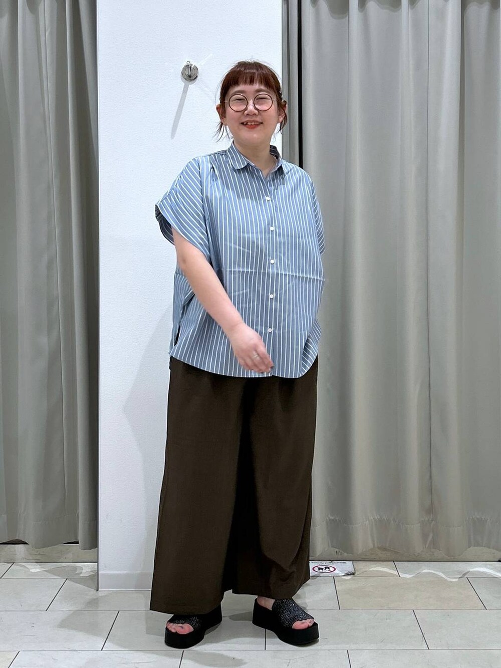 ブラック系のサンダル、ホワイト系のショルダーバッグ、ブラウン系のスラックスを着用したレディースの夏コーディネートの3枚目の写真