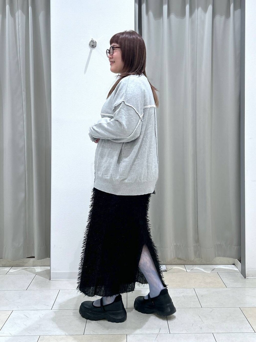 ブラック系のスニーカー、グレー系のスウェット、ブラック系のスカートを着用したレディースの秋コーディネートの3枚目の写真