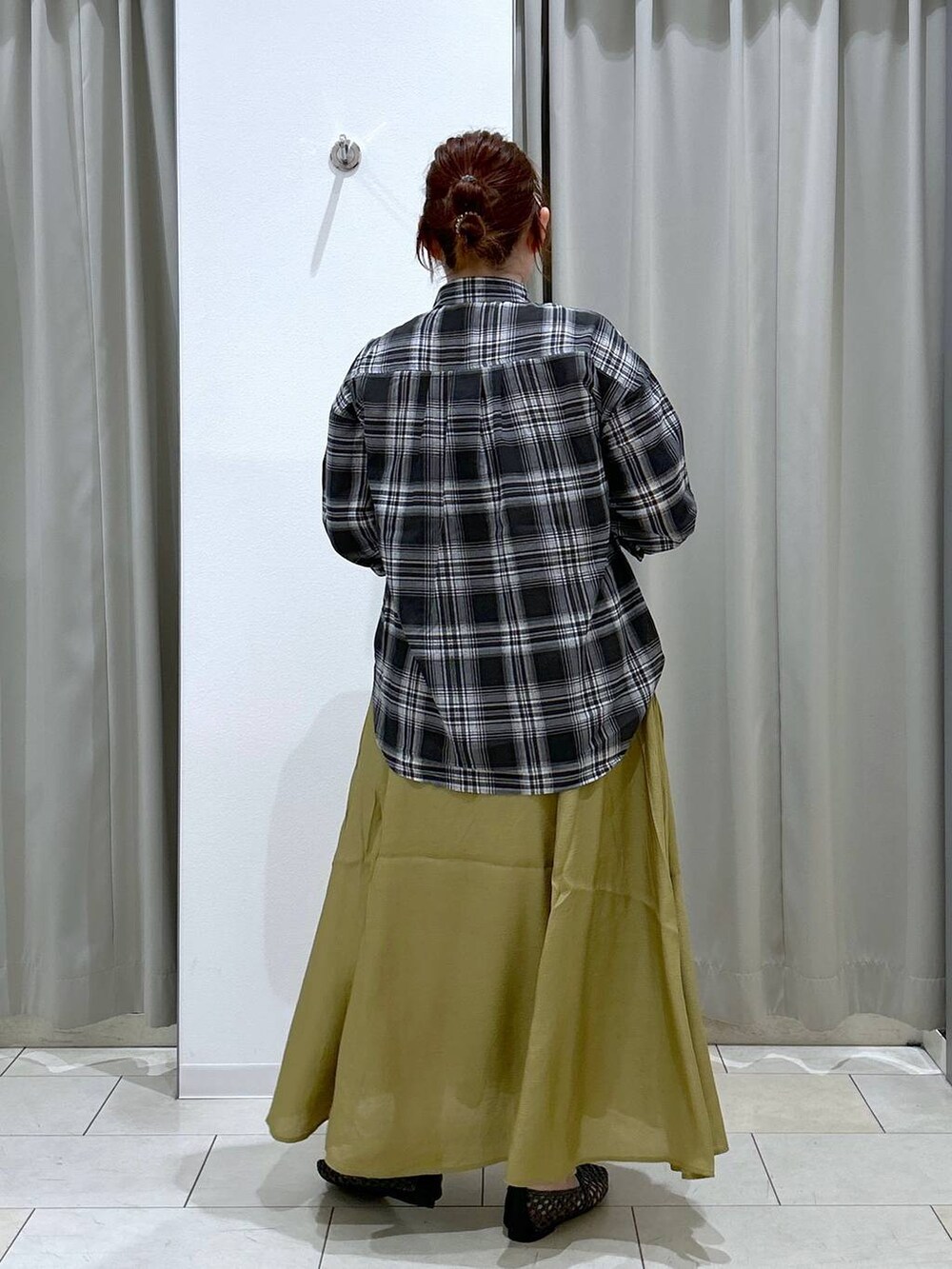 グリーン系のキャミソール、ブラック系のトートバッグ、イエロー系のスカートを着用したレディースの夏コーディネートの5枚目の写真