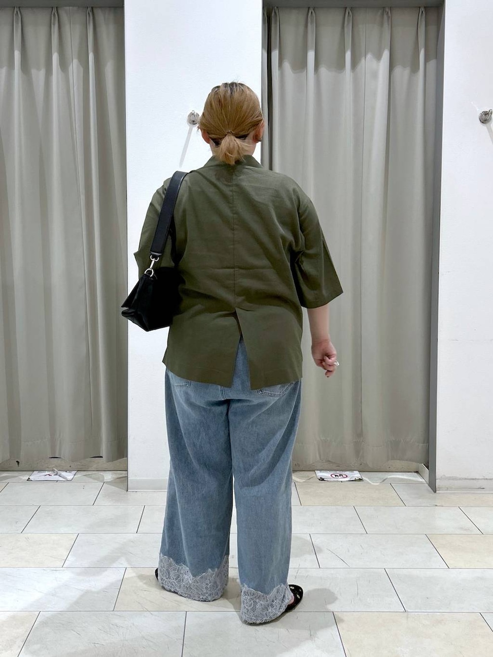 ブルー系のデニムパンツ、ブラック系のショルダーバッグ、ブラウン系のバレエシューズを着用したレディースの夏コーディネートの6枚目の写真